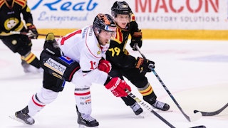 Örebros Aaron Palushaj i vitt närmast bild i duell med en Brynässpelare.