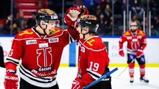 Två Örebro-spelare i röda tröjor gör high five i förgrunden. I bakgrunden ansluter en tredje Örebro-spelare.