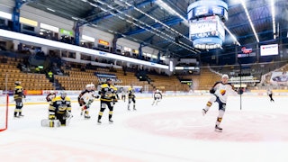 En Djurgårdsspelare till höger jublar med klubban i luften medan HV71-spelare deppar